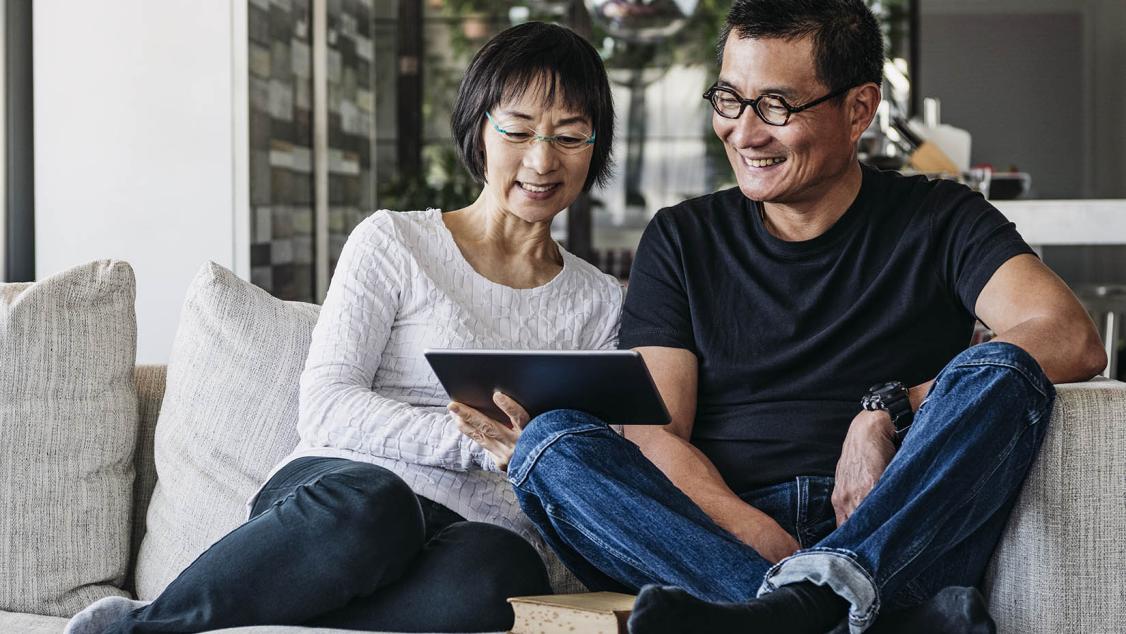 Smiling man and woman looking at tablet together